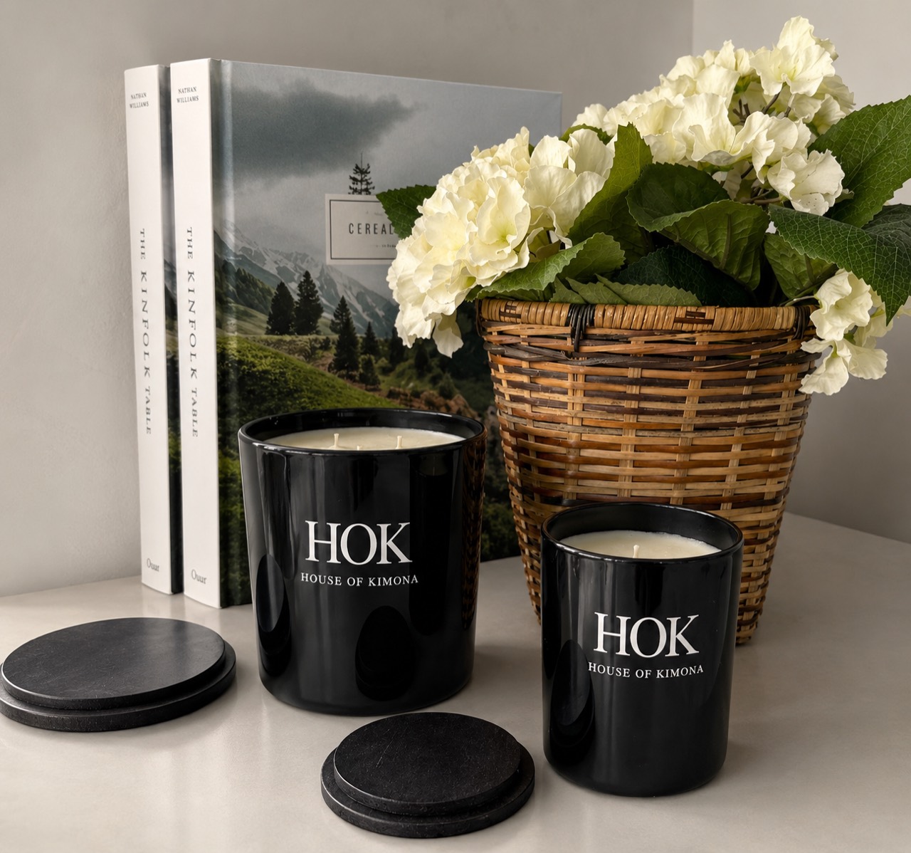 Velas negras House of Kimona junto a flores blancas